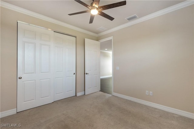 unfurnished bedroom featuring ceiling fan, light colored carpet, and crown molding