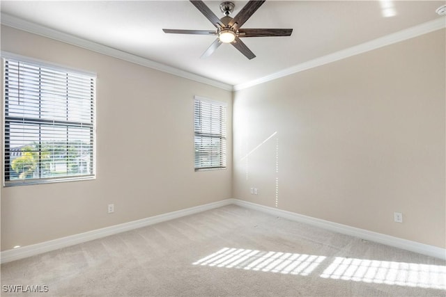 carpeted empty room with ceiling fan, plenty of natural light, and crown molding