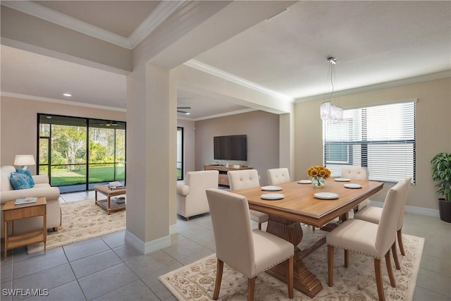 dining area with light tile patterned floors, ornamental molding, and a notable chandelier