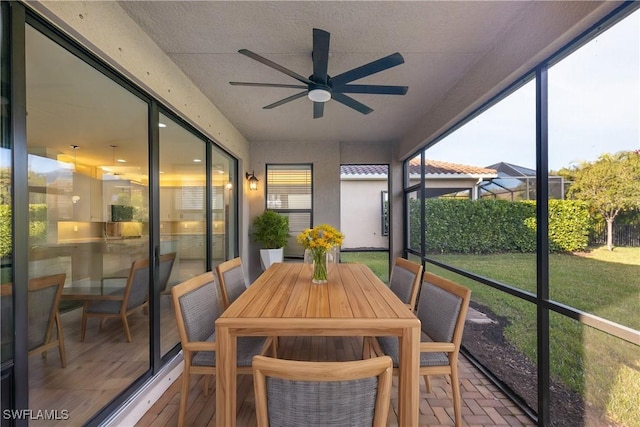 sunroom / solarium featuring ceiling fan