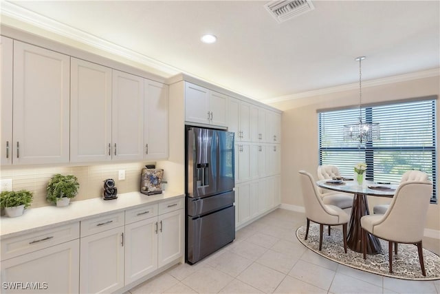 kitchen featuring pendant lighting, backsplash, crown molding, stainless steel fridge with ice dispenser, and white cabinetry