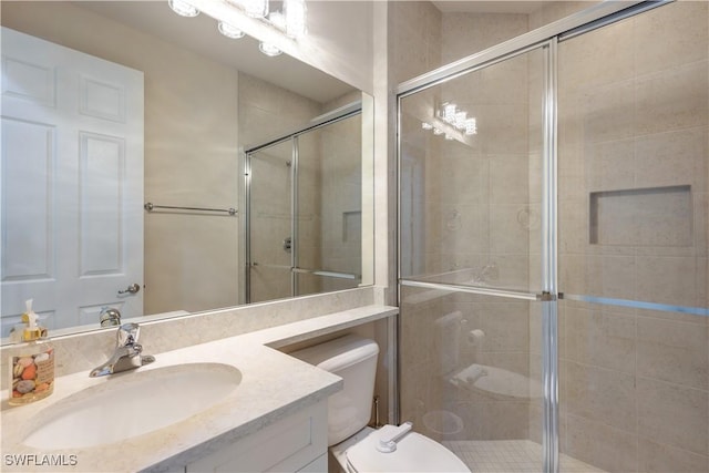 bathroom featuring vanity, an enclosed shower, and toilet