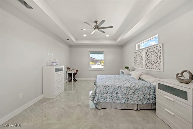 bedroom with a tray ceiling and ceiling fan