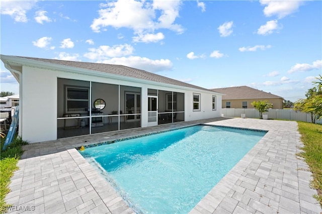 view of swimming pool featuring a sunroom and a patio