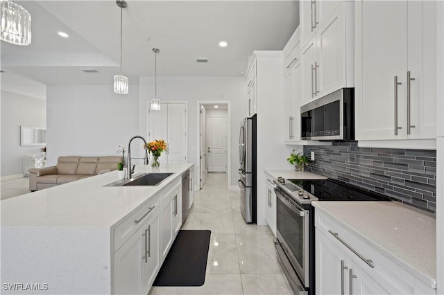 kitchen with white cabinets, decorative light fixtures, stainless steel appliances, and sink