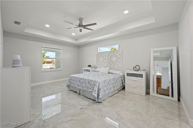 bedroom featuring a raised ceiling and ceiling fan