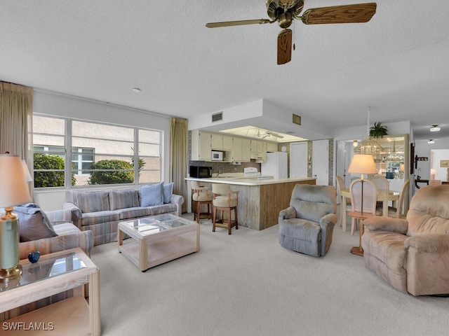 carpeted living room featuring a textured ceiling and ceiling fan