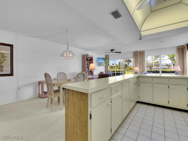 kitchen featuring kitchen peninsula, ceiling fan, hanging light fixtures, and light tile patterned flooring