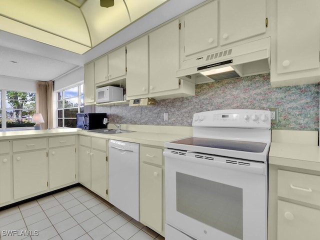 kitchen featuring white appliances, extractor fan, sink, light tile patterned floors, and cream cabinets