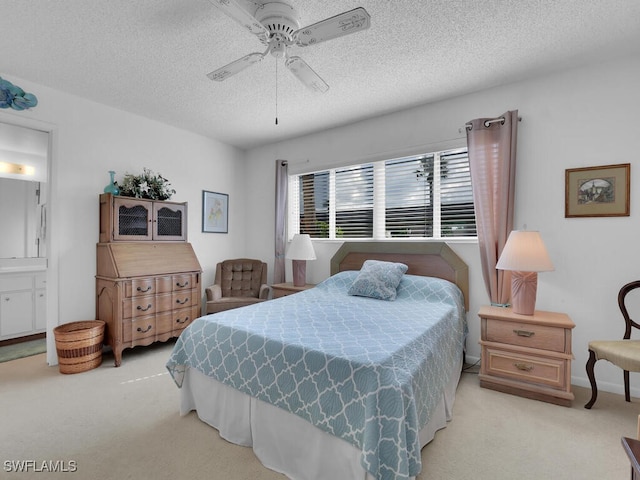 bedroom with light carpet, a textured ceiling, connected bathroom, and ceiling fan