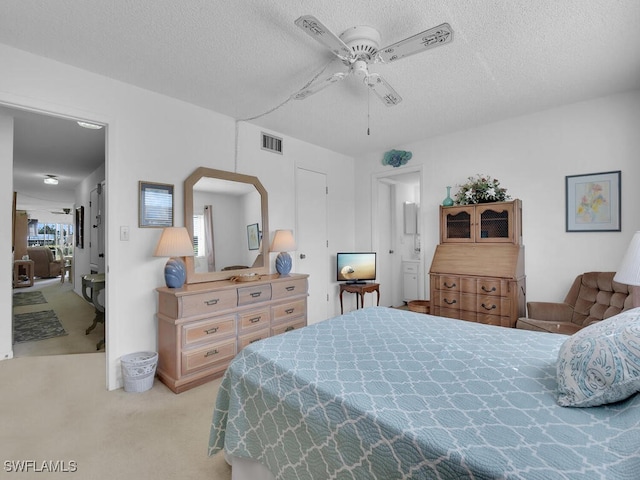 bedroom with a textured ceiling, light colored carpet, and ceiling fan