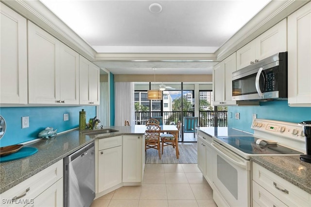 kitchen with stainless steel appliances, sink, light tile patterned floors, pendant lighting, and white cabinets