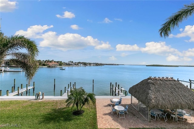 dock area with a lawn, a patio area, a water view, and a gazebo