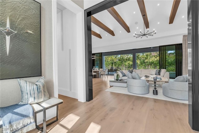 living room with beamed ceiling, light hardwood / wood-style flooring, and an inviting chandelier