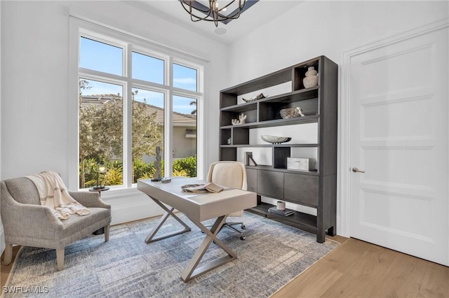 office with hardwood / wood-style floors and a notable chandelier