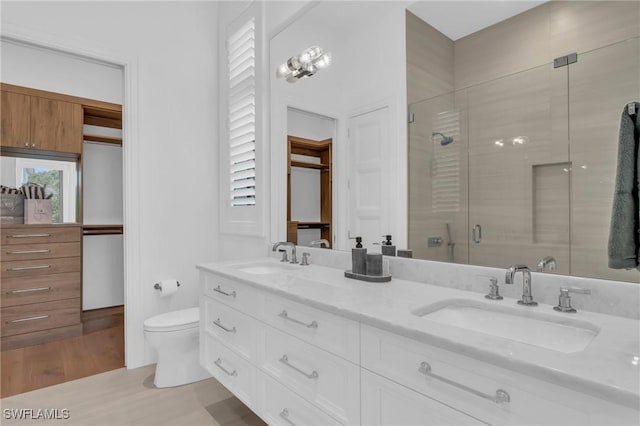 bathroom featuring hardwood / wood-style flooring, toilet, vanity, and walk in shower