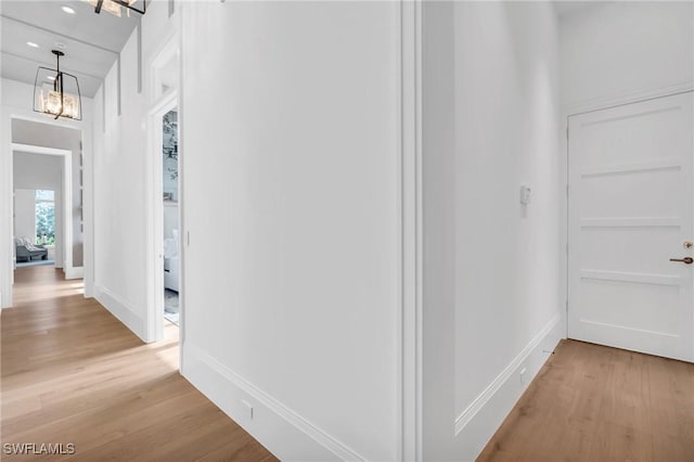 corridor featuring a chandelier and light wood-type flooring