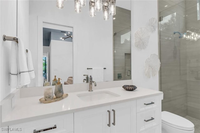 bathroom featuring vanity, toilet, and a shower with shower door