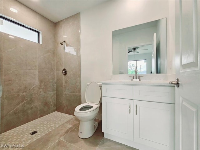 bathroom featuring vanity, tile patterned floors, ceiling fan, toilet, and tiled shower