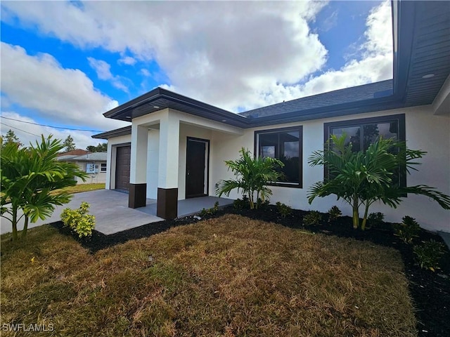 property entrance with a garage and a yard