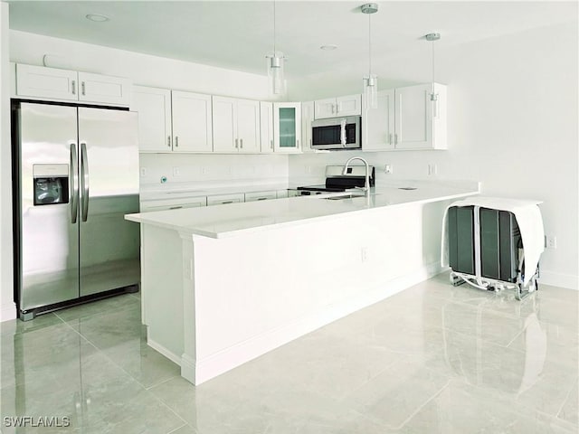 kitchen with white cabinetry, sink, kitchen peninsula, decorative light fixtures, and appliances with stainless steel finishes