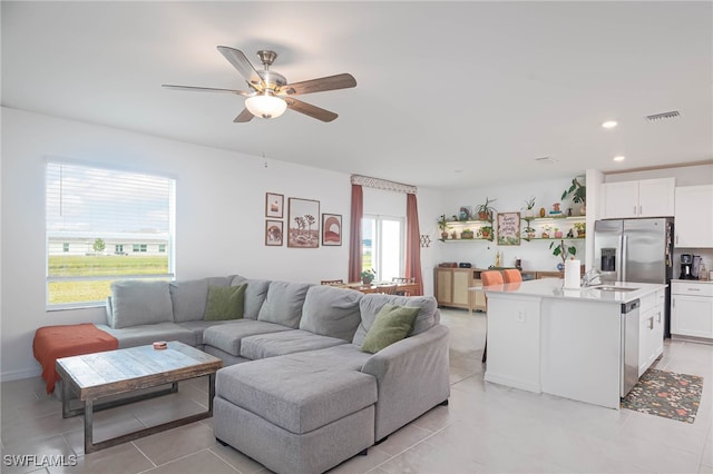 tiled living room featuring ceiling fan and sink