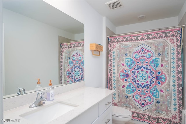 bathroom featuring vanity, toilet, and curtained shower