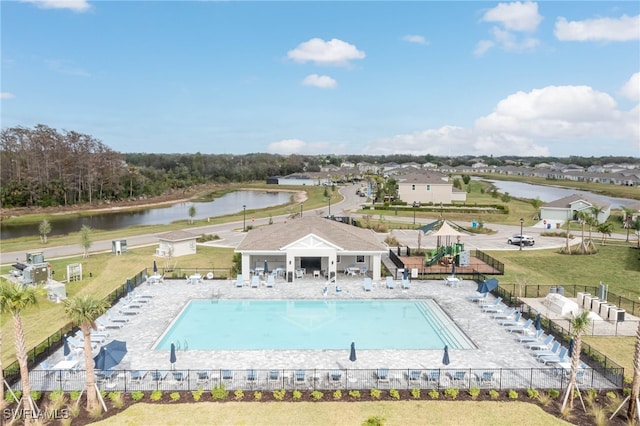 view of swimming pool with a patio area, a yard, and a water view