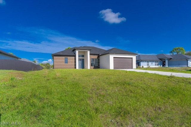 view of front of property with a front yard and a garage