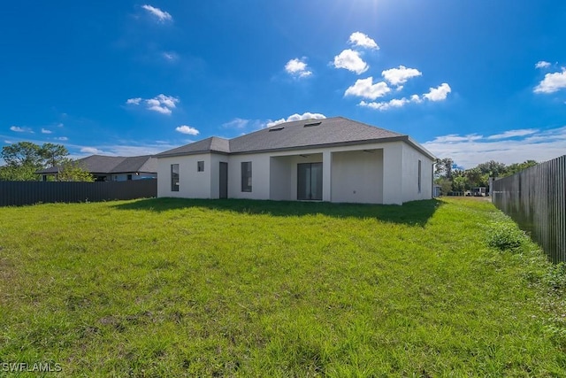 back of house with a lawn