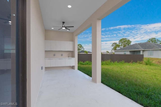 view of patio / terrace with a ceiling fan and fence