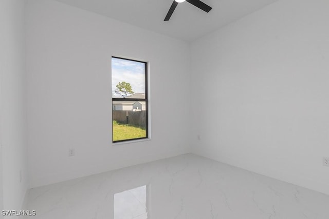 spare room with ceiling fan and marble finish floor