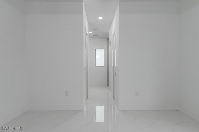 corridor featuring recessed lighting, marble finish floor, and baseboards