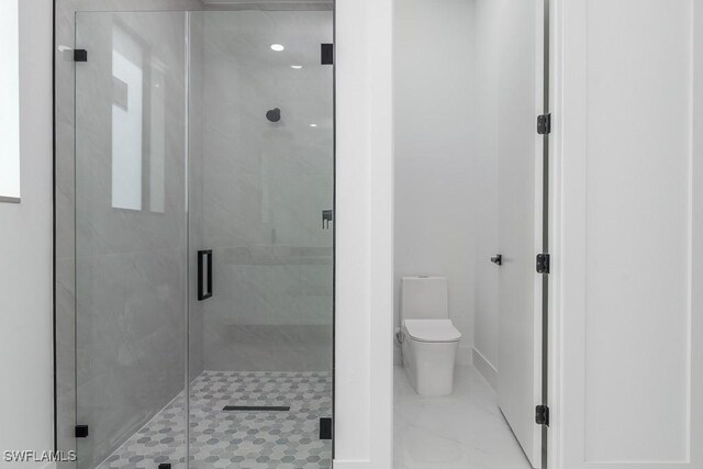 bathroom featuring toilet and a shower stall