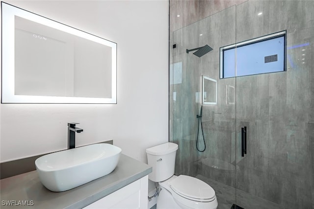 bathroom featuring vanity, toilet, and a shower with door