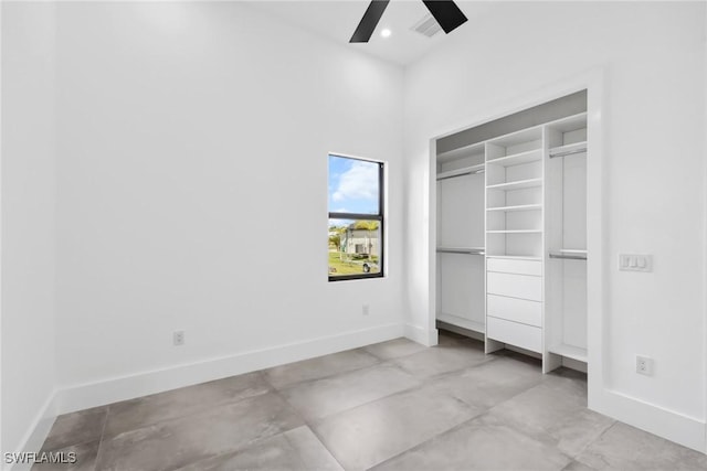 unfurnished bedroom featuring a ceiling fan, a closet, and baseboards