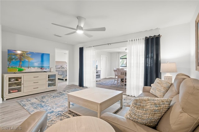 living room with light hardwood / wood-style flooring and ceiling fan