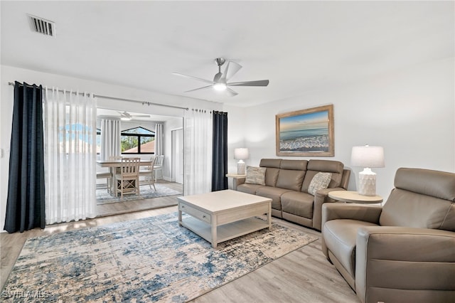 living room with ceiling fan and light wood-type flooring