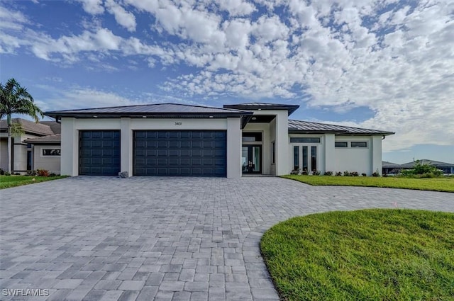 prairie-style home with a front lawn and a garage