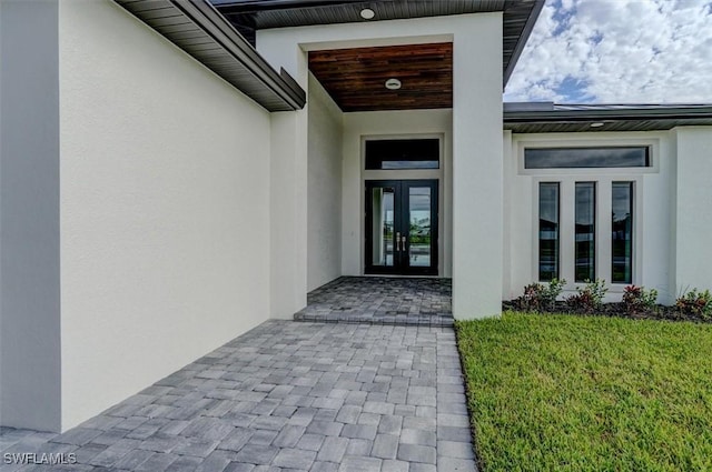 entrance to property with a lawn and french doors