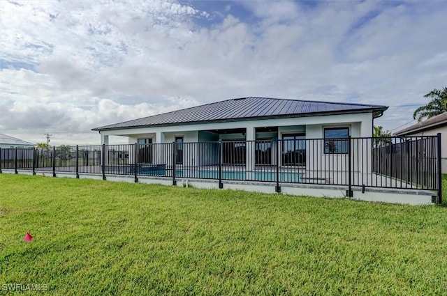 back of house with a fenced in pool and a yard