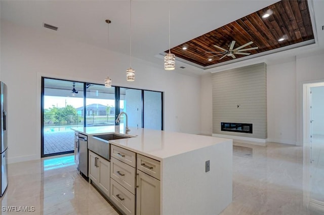 kitchen with stainless steel appliances, sink, wooden ceiling, a fireplace, and an island with sink