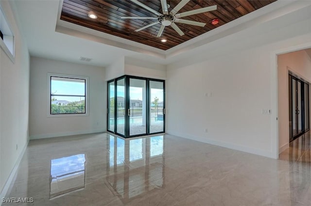 unfurnished room featuring ceiling fan, wood ceiling, french doors, and a tray ceiling