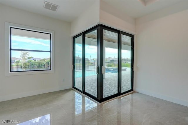 entryway with plenty of natural light, a water view, and french doors