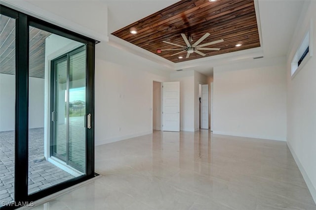 empty room featuring a raised ceiling, ceiling fan, and wooden ceiling