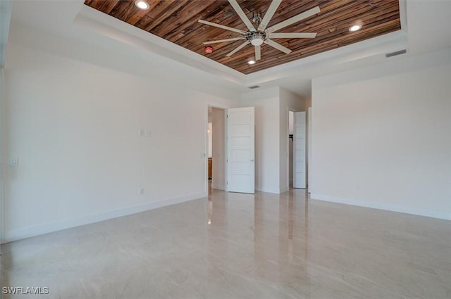 spare room with a tray ceiling, ceiling fan, and wood ceiling