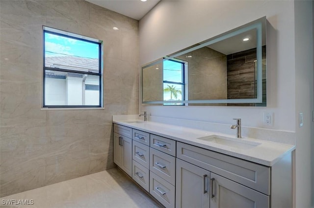 bathroom featuring vanity and tile walls