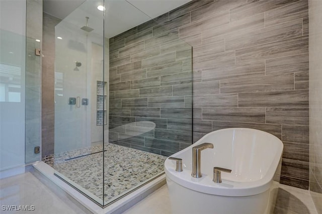 bathroom featuring tile walls and plus walk in shower