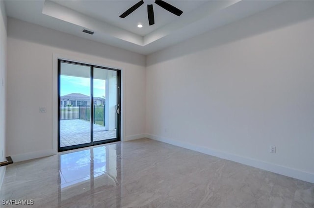 unfurnished room featuring ceiling fan and a tray ceiling