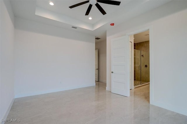 spare room with a raised ceiling and ceiling fan